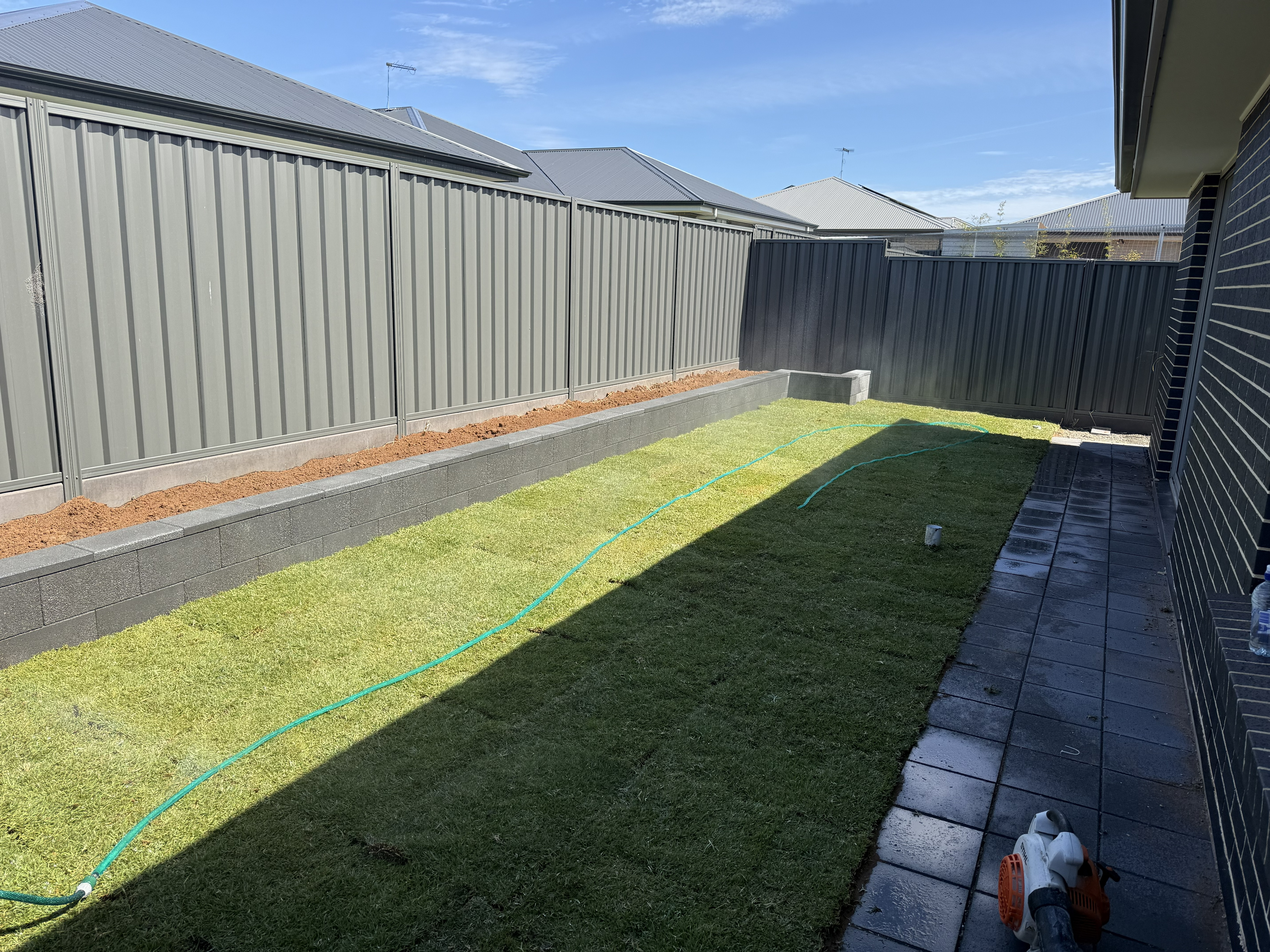 Landscaping Morphett Vale backyard with fresh turf and garden beds
